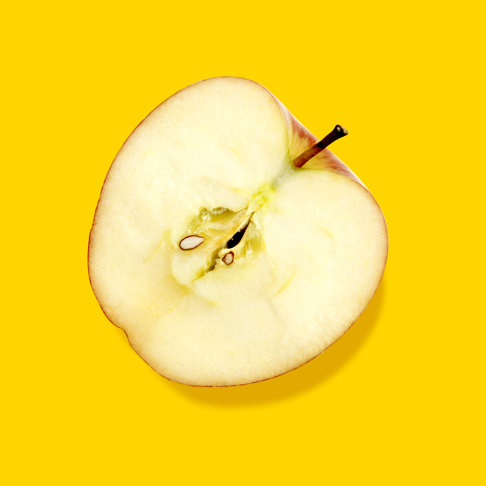 Halber Apfel auf gelben Hintergrund